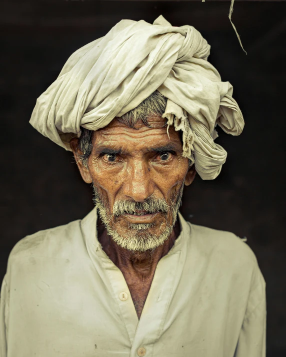 a man with a white turban wearing a black hat