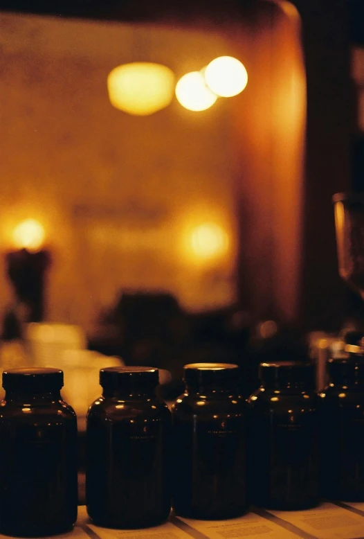 bottles and jars sit on a table with some glasses on it