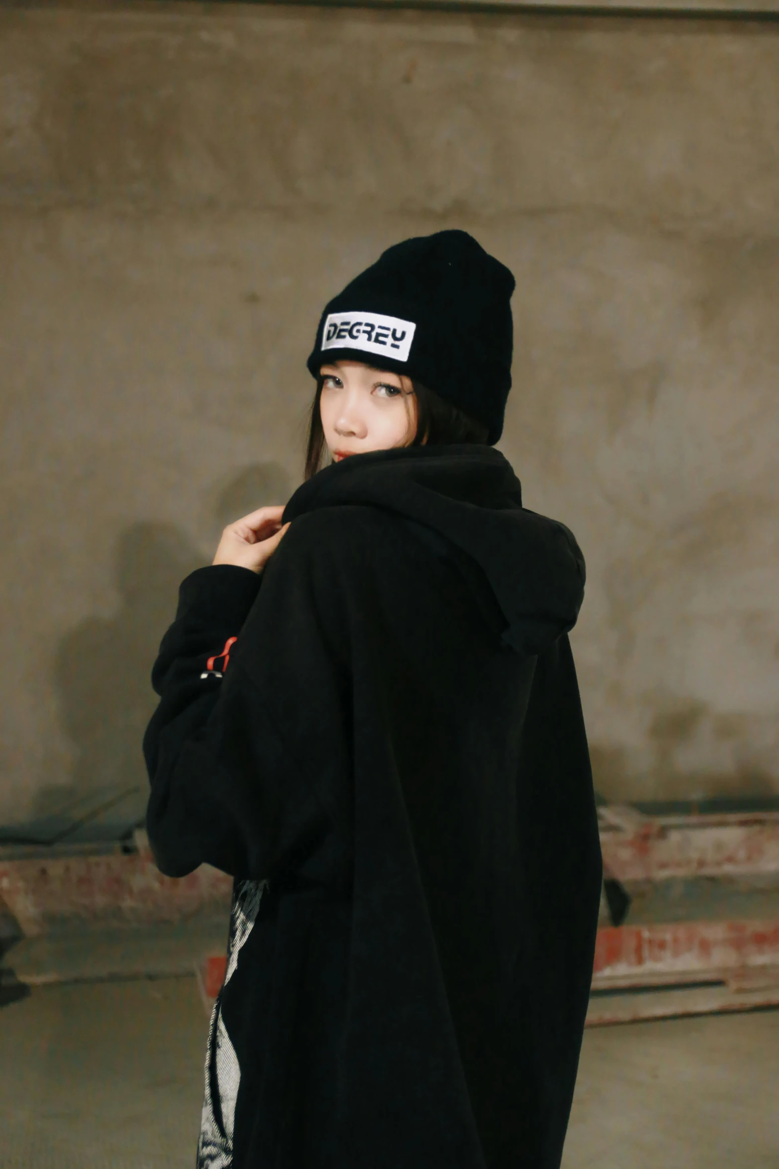 a girl wearing a coat and hat that is black