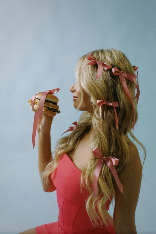 a woman with long blonde hair is eating a sandwich