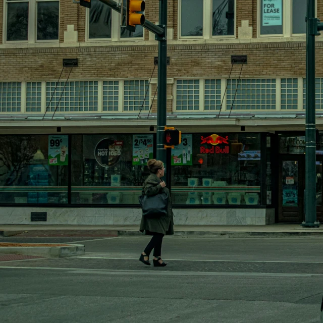 a woman crossing a street with a traffic light