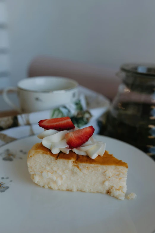 a slice of cake on top of a plate next to a teapot