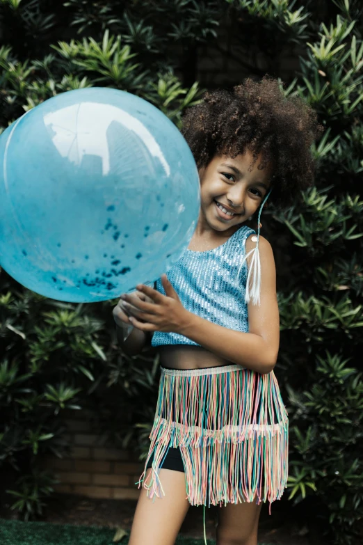  smiling with a blue balloon in front of her