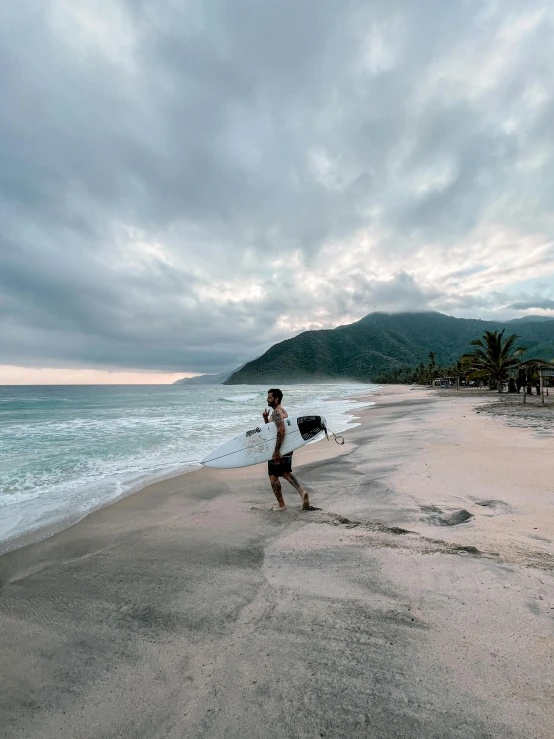 a man is running on the beach near water