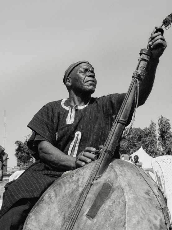 black and white pograph of a man holding an instrument on his hip