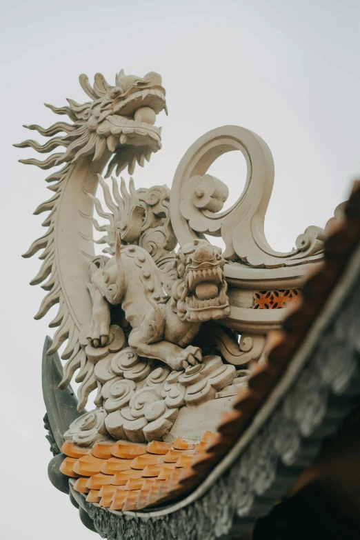 a decorative roof has a dragon sculpture on it