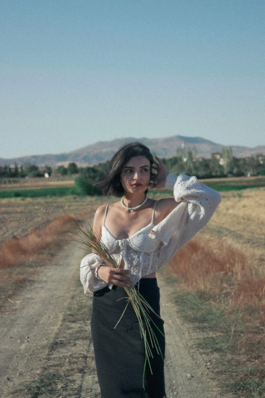 a woman with crop seeds and hair standing in the middle of the road