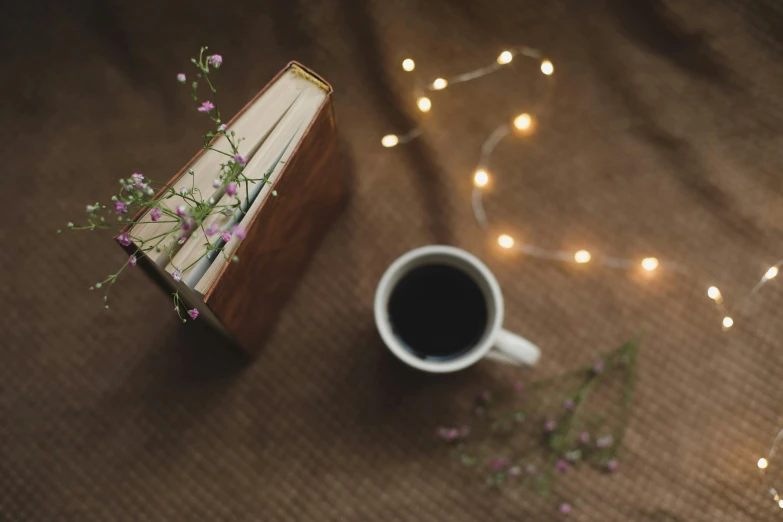 an open book on a table with a cup of coffee