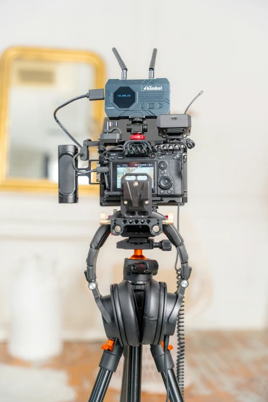 the camera is connected to a tripod with an orange and black handle