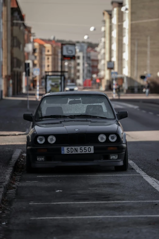 an old car parked at the curb of a street