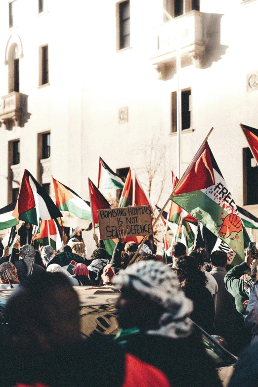 people holding up protest signs in front of a building