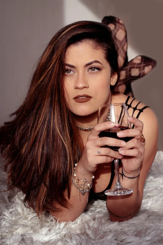 a young woman is holding a small wine glass