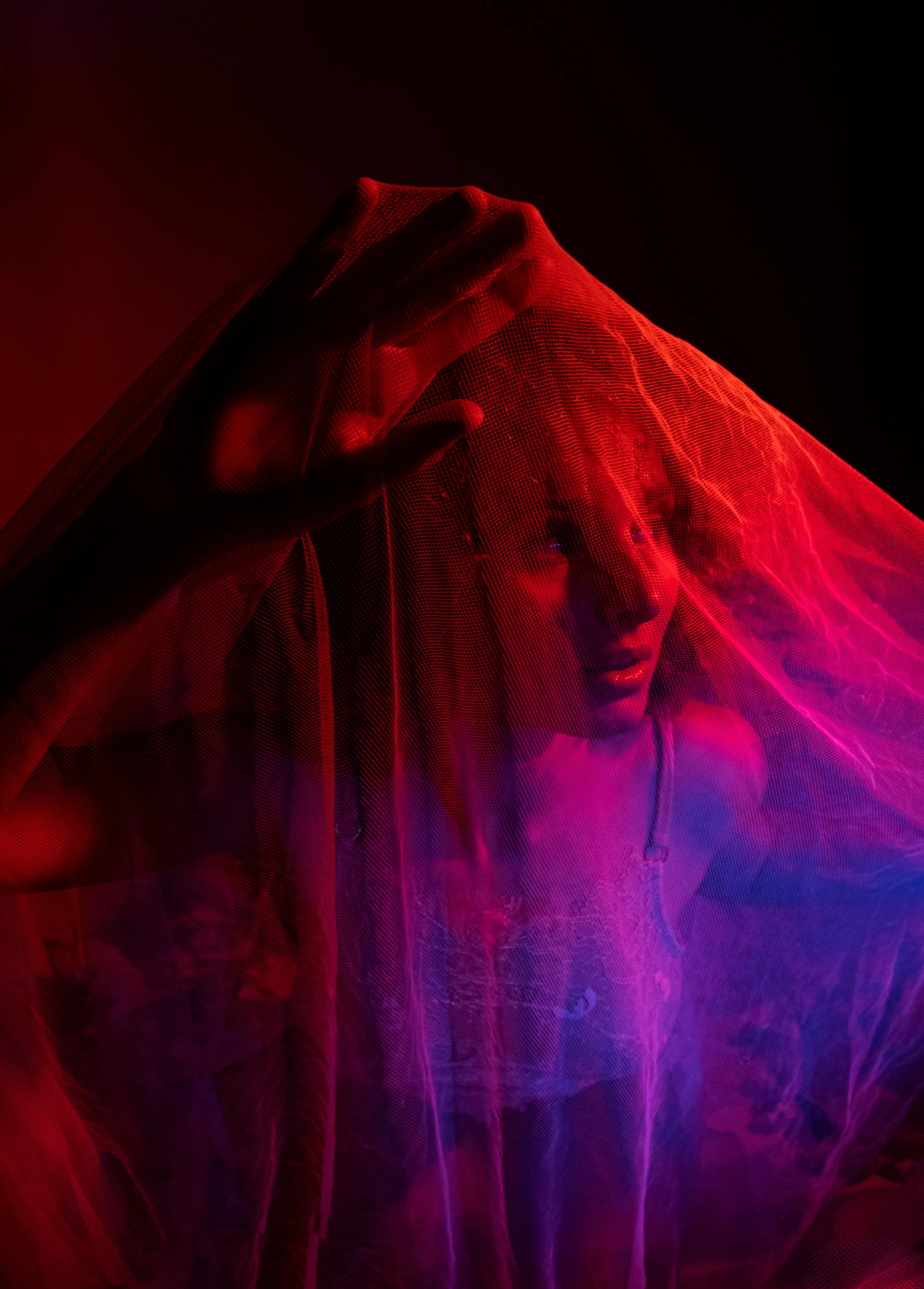 a woman's hands with red and purple lighting