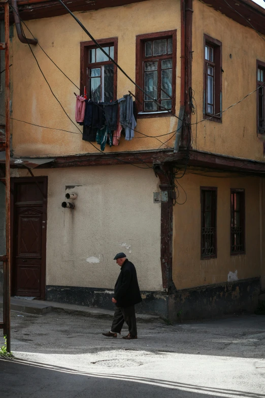 a person is walking by a building with clothes hanging from it