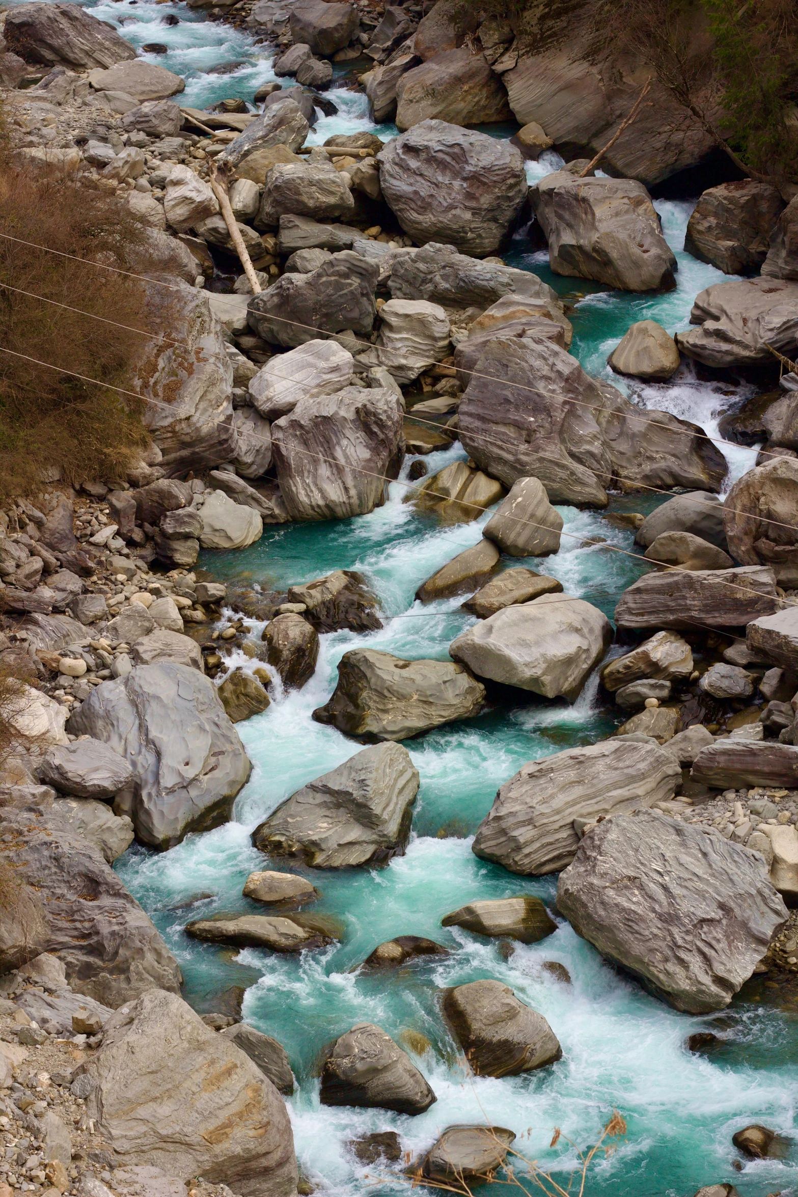 a stream with small rocks and bright blue water