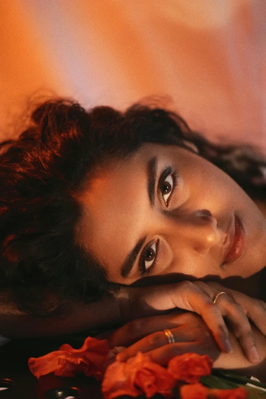 a woman laying on top of a table with orange flowers