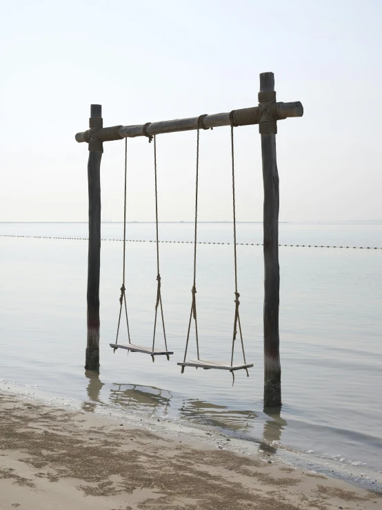 there are two wooden swings hanging from the water