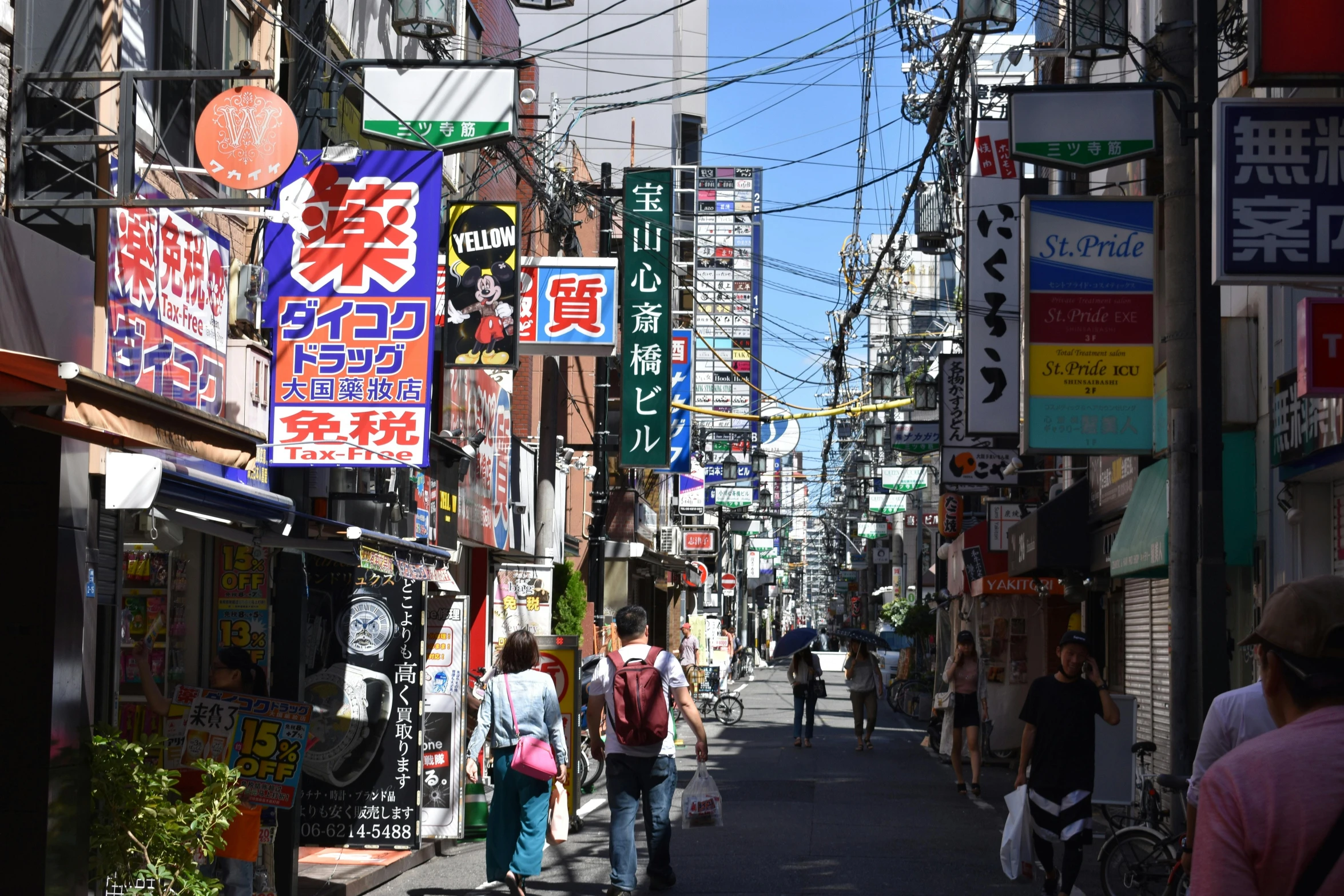 the back alley of an asian city has numerous stores and people