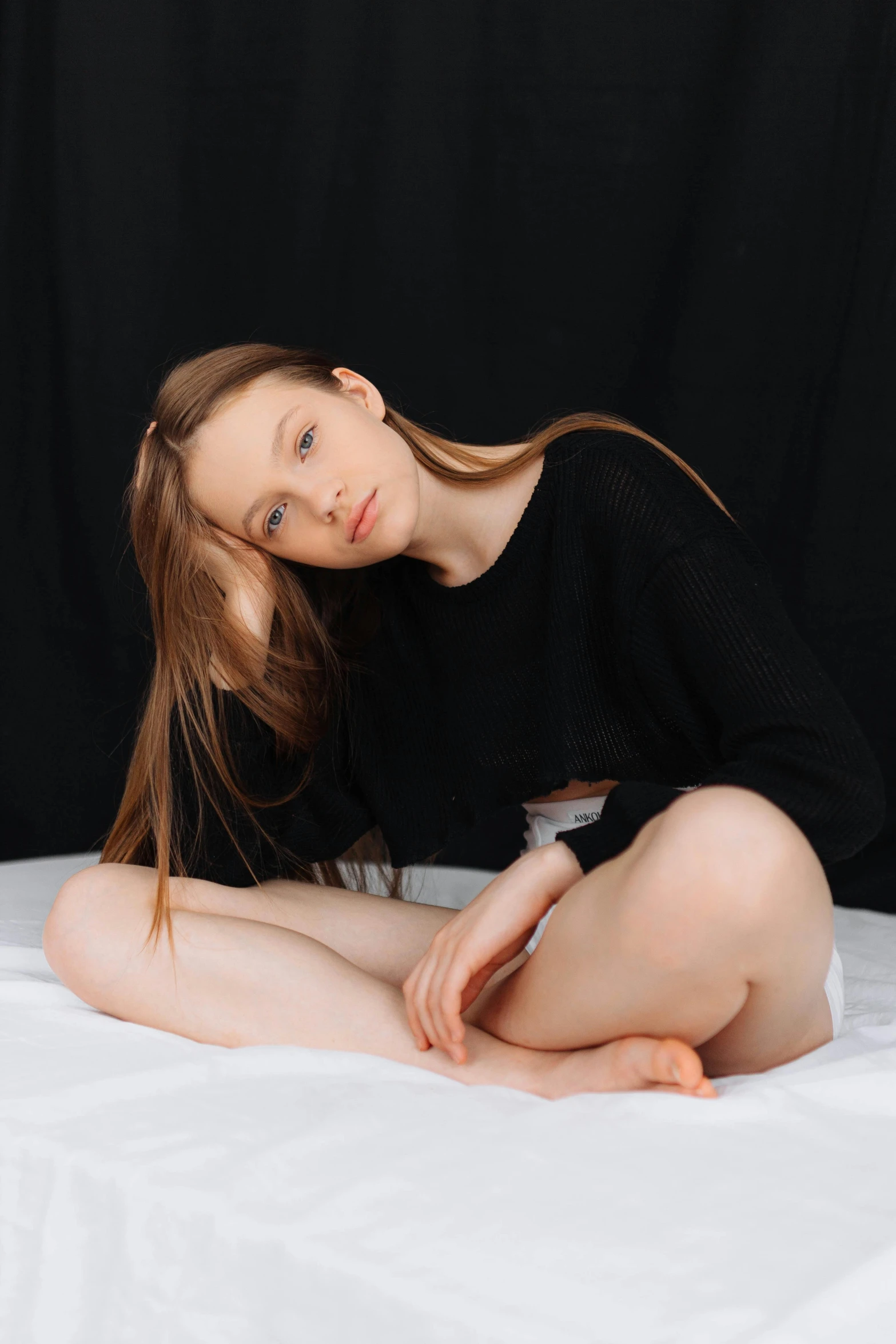 a very beautiful young woman posing on a bed