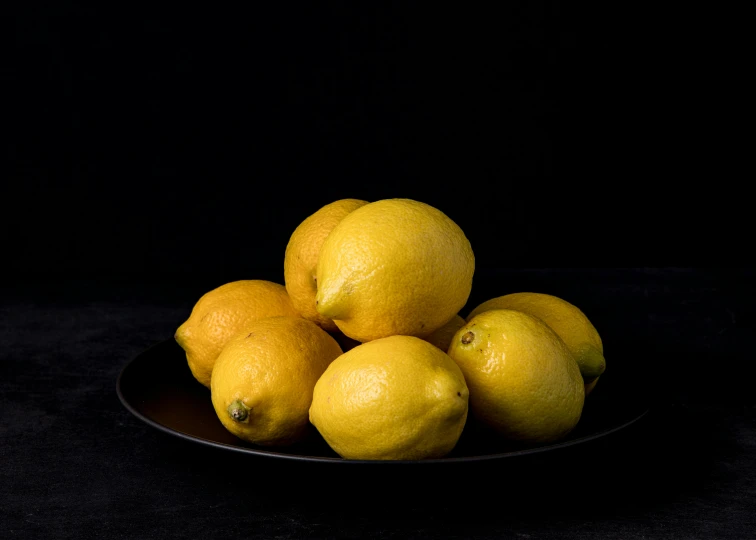 a plate filled with lemons in the dark