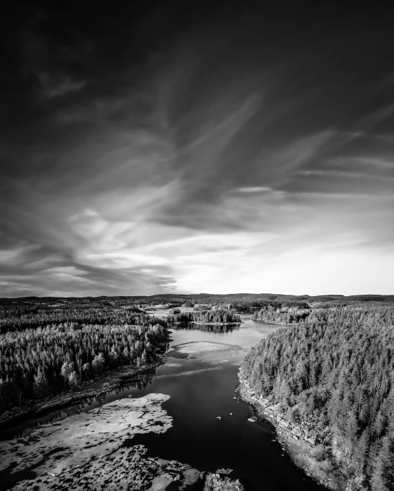 dark sky and clouds over a river with sp trees