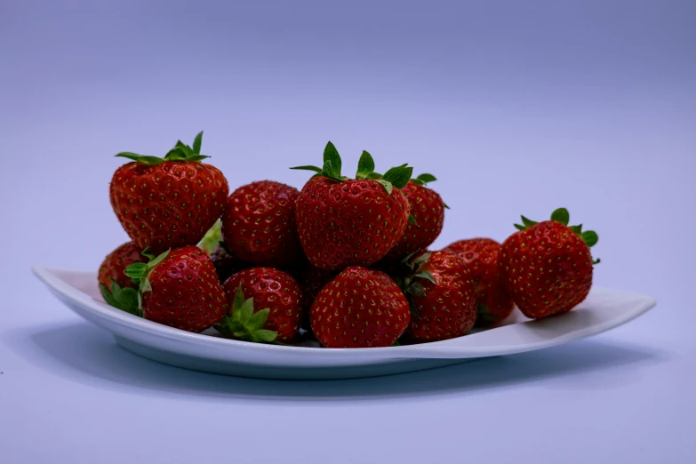 a bowl full of strawberries on a white plate