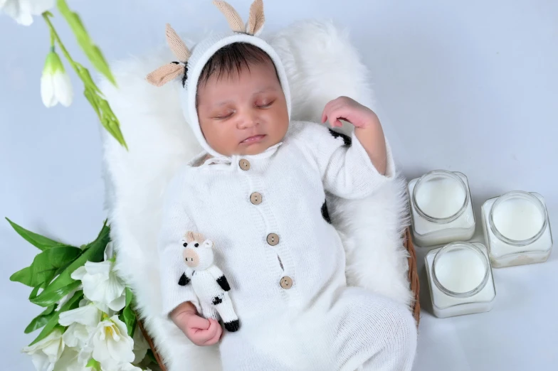 a baby sleeps on top of a blanket with some candles around it