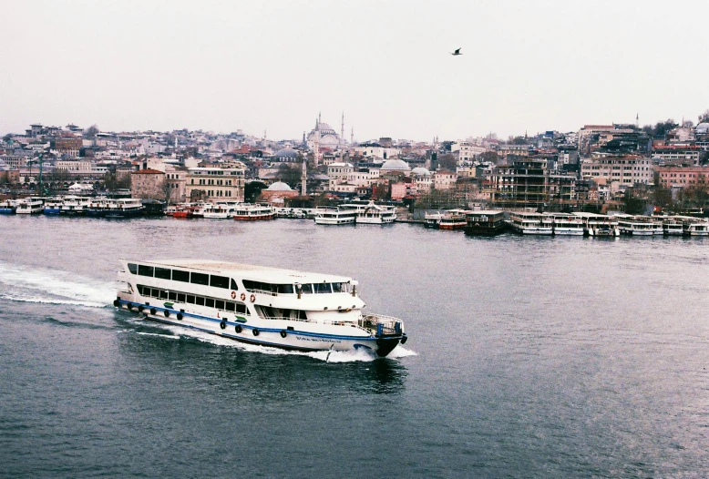 a river boat travels down the water near some buildings