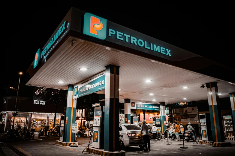 people waiting at a gas station with lights on