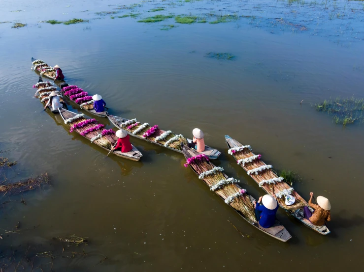 a row boat filled with people floating on top of a river