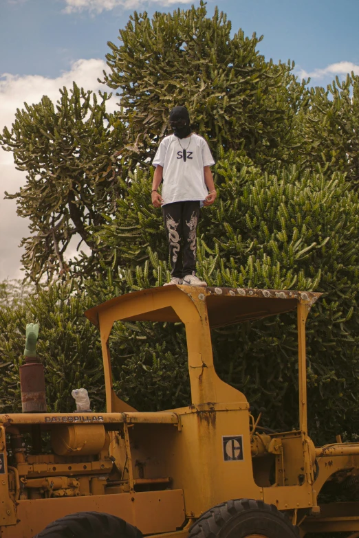 a person standing on top of a yellow vehicle