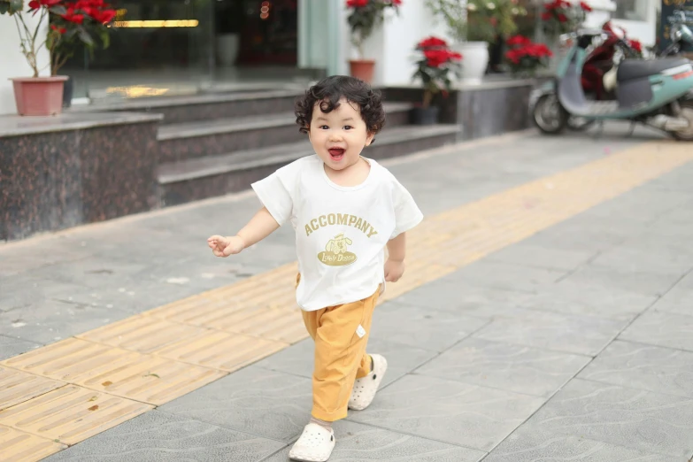 a child is walking on the street in front of flowers