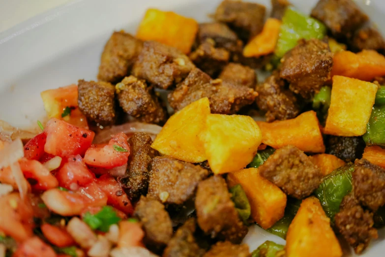 a small dish of meat and vegetables served on a plate