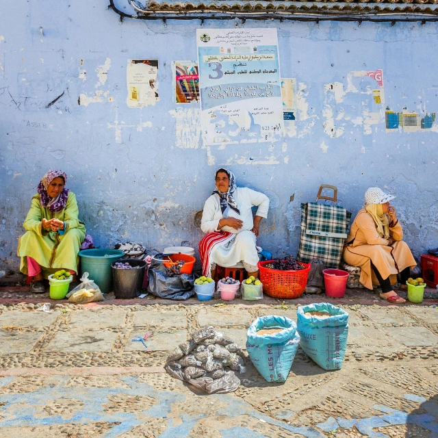 two woman sitting on the side of a building