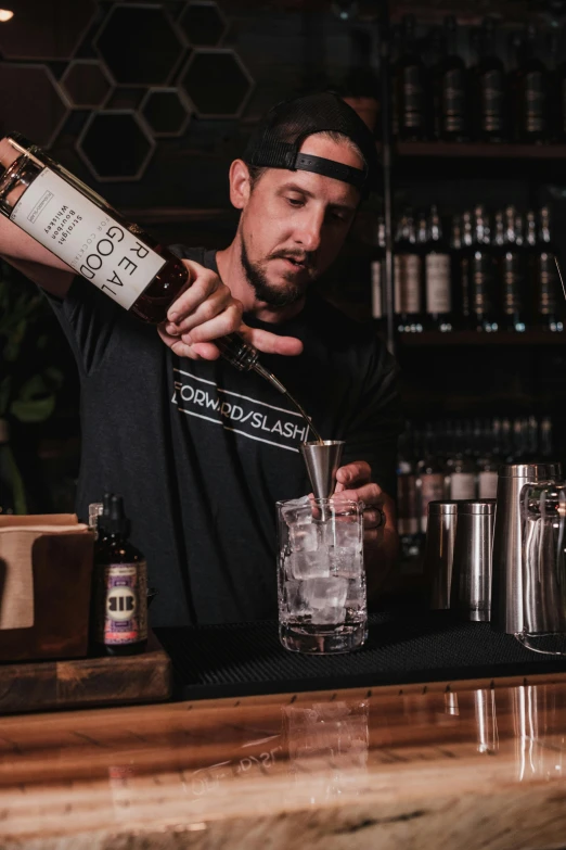 a man standing behind a bar pouring glasses