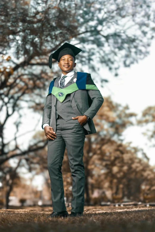 a man with a graduation gown and cap poses for a po