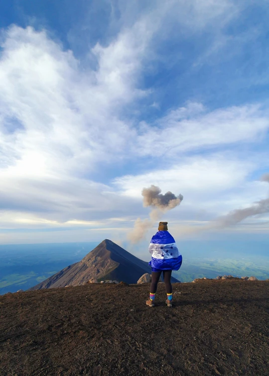 person standing on top of a mountain looking at the view