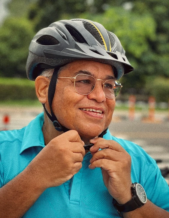 man adjusting his bike helmet and smiling at camera