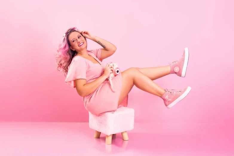 the woman is posing in a pink dress