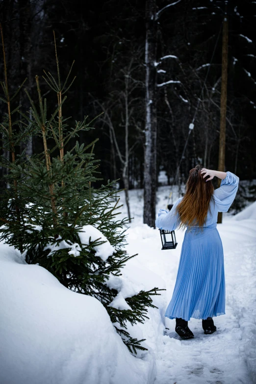 a woman dressed in blue walking through snow