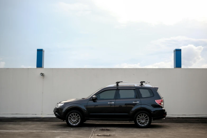 a vehicle parked next to a white wall