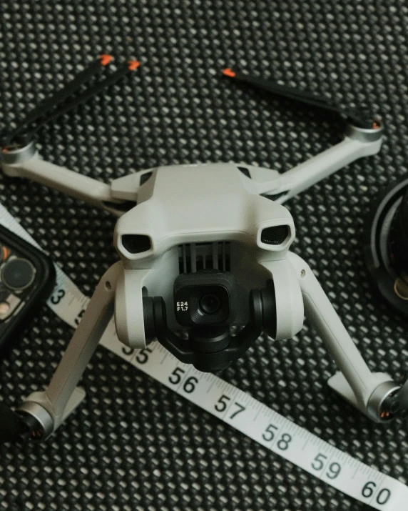 a white quad robot is sitting on a gray fabric