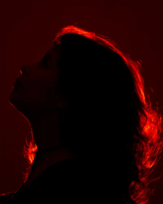 a person in silhouette in an orange light