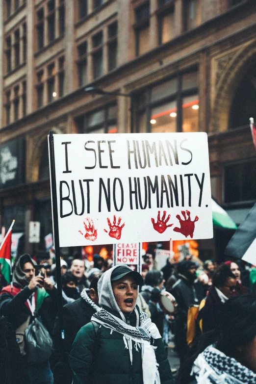 a crowd of protesters standing on the side of a street