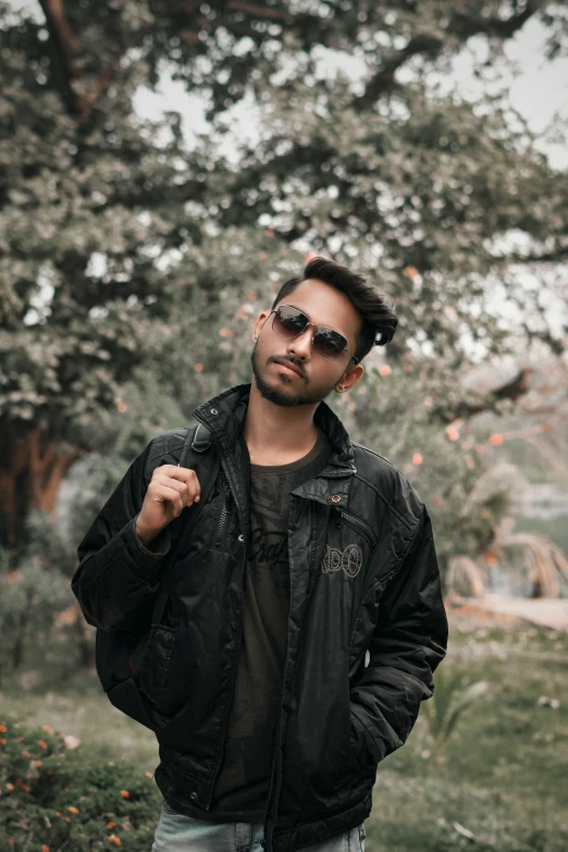 the young man stands alone in a park