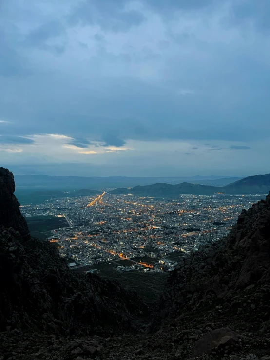 a view from atop a mountain in the evening with lights lit up