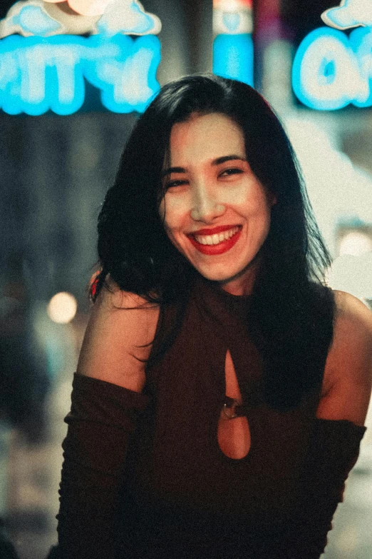 a woman smiles and is standing in front of a building