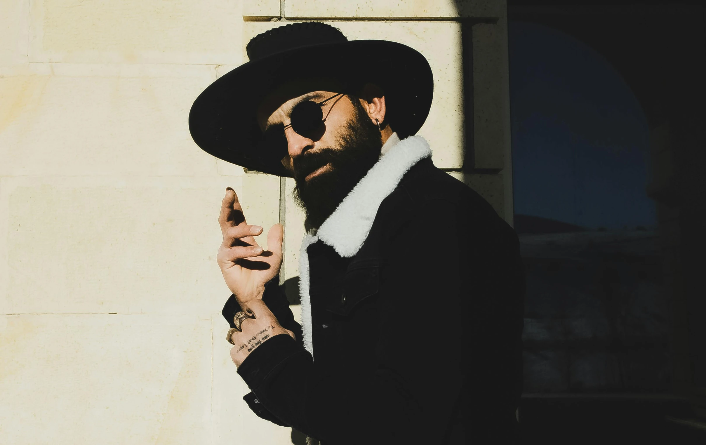 a man with beard and sunglasses smoking a cigarette