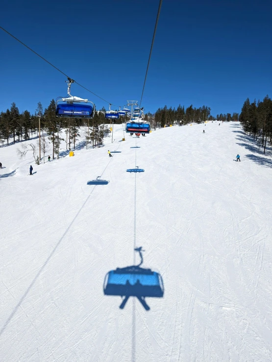 the ski lift is above a slope on a clear day