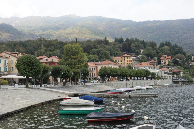 several boats are docked at a dock near a town